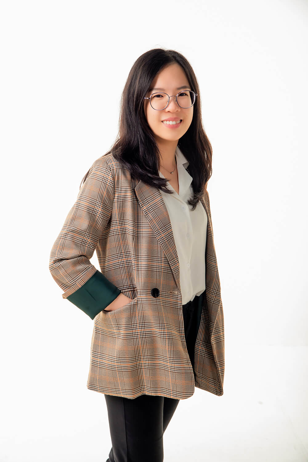 Smiling optometrist with glasses, wearing a plaid blazer, representing the friendly face of professional optical care.