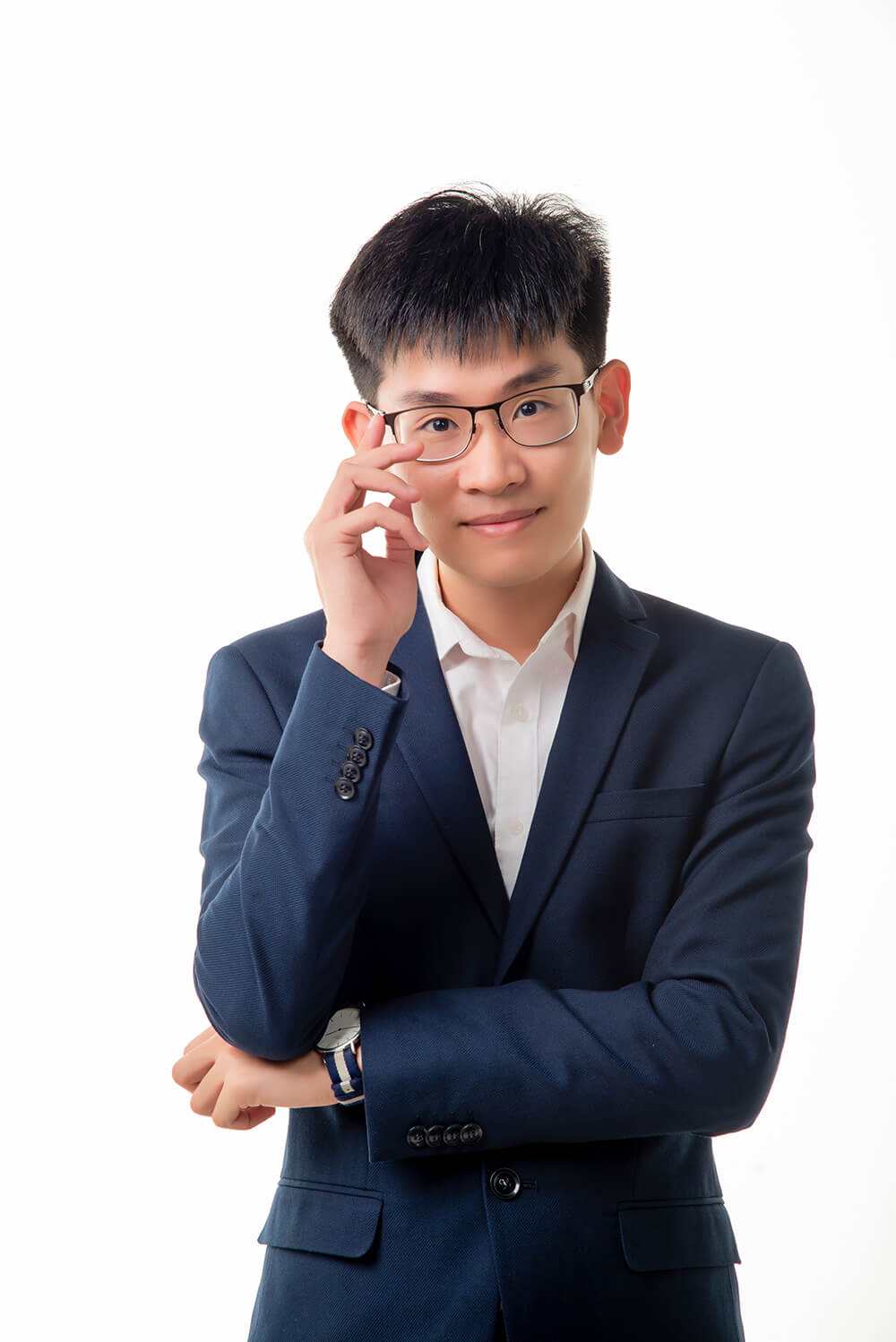 Confident young optometrist adjusting glasses, dressed in a formal blue suit, symbolizing precision in optical care.