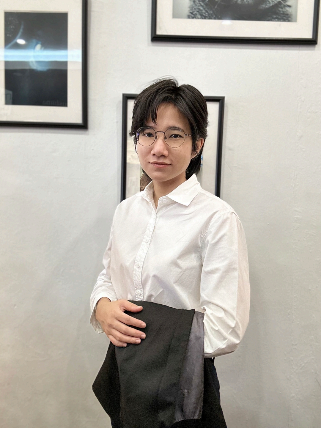 Contemporary optometrist in a classic white shirt and glasses, exemplifying modern eye care in an art gallery setting.