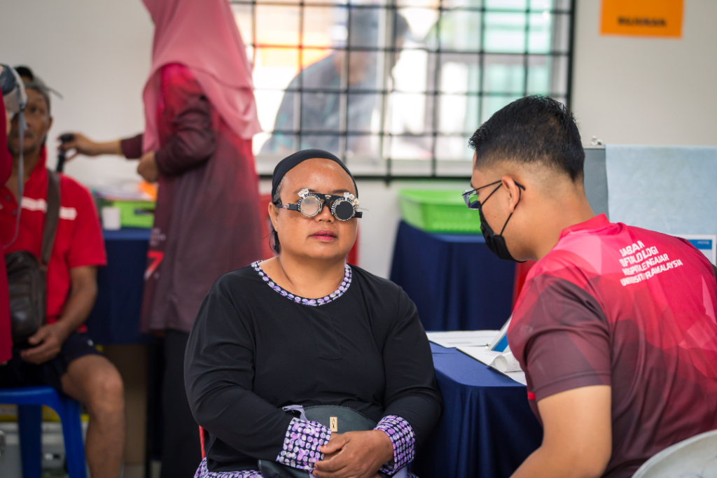 Optometrist from Top One Optical conducting eye care screenings in collaboration with members from The Tribe Project for the residents in Hulu Langat